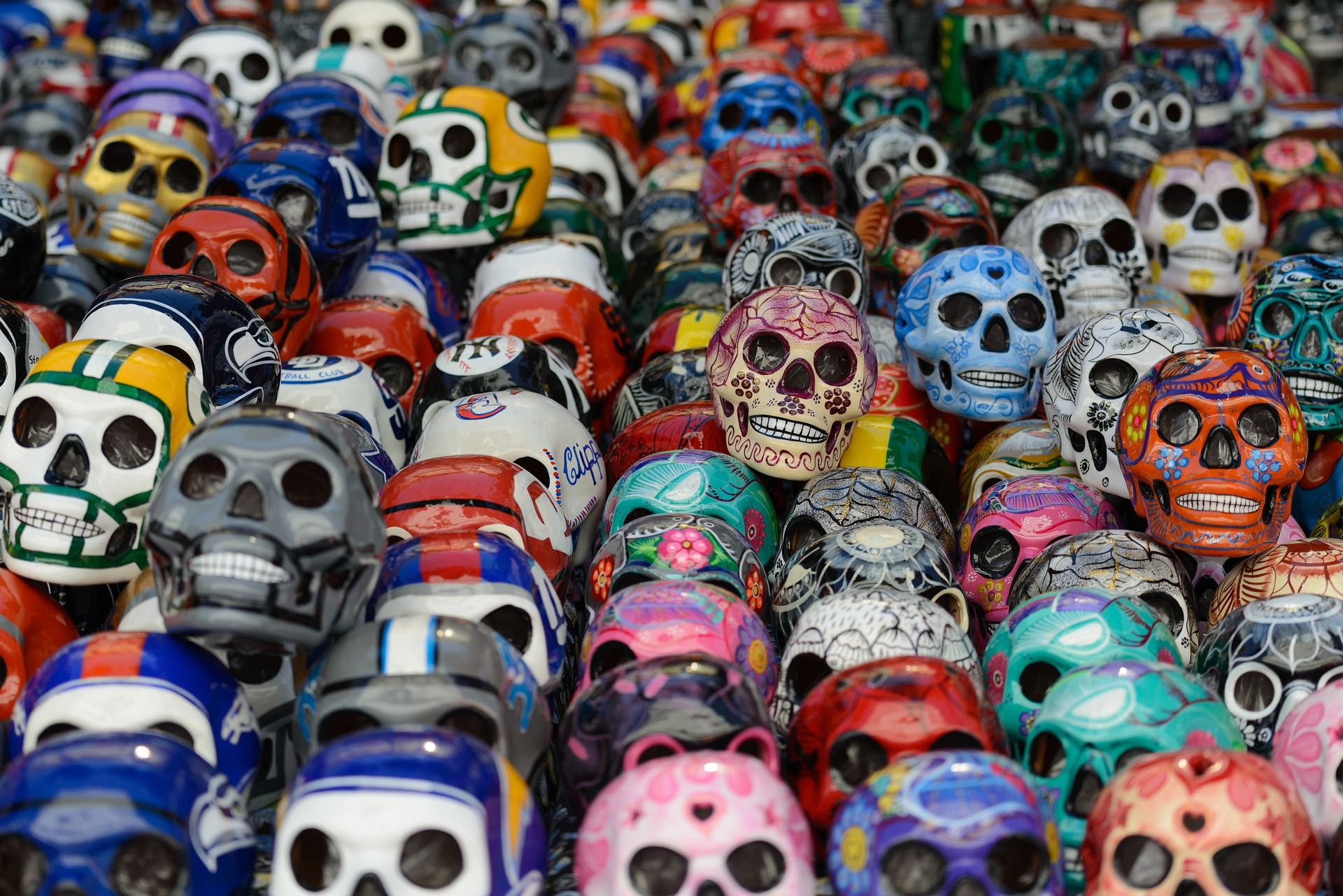Colorful decorated sugar skulls stacked together, featuring traditional Day of the Dead designs and vibrant patterns.